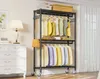 A black metal garment rack with clothes hanging on it, placed in a room next to a white dresser and lamp. Voir les images du produit