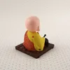 A small figurine of a meditating Buddha sits on a wooden platform. Produktbild-Vorschau