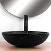 A black marble-effect vessel sink with a black faucet is shown in a bathroom setting, with a large round mirror reflecting the scene. Anteprima dell’immagine prodotto