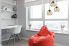 A modern room with a desk, chair, and beanbag chair next to a large window. Voir les images du produit