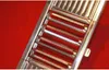 A close-up view of a metal vegetable slicer with red inserts against a red background. Produktbild-Vorschau