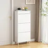 A white shoe cabinet with three flip-down drawers is shown in a room next to a white door and curtains. Produktbild-Vorschau