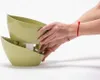Hands holding two stacked green planters. Náhled obrázku produktu