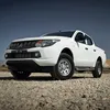 A white pickup truck parked on a gravel surface with a clear blue sky in the background. Produktbild-Vorschau