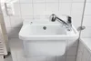 A white sink with a chrome faucet mounted on a tiled wall. Anteprima dell’immagine prodotto