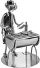 A metal figurine of a person grilling fish on a barbecue. Produktbild-Vorschau