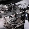 A collage showing a close-up of a person's hands wearing gloves, using a ratchet and an Allen key to work on a car engine. Náhľad obrázku produktu