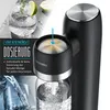 Close-up of a black Arendo water carbonator with a glass of sparkling water and lime in the background. Produktbild-Vorschau