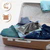 A suitcase packed with clothes and a travel iron. Produktbild-Vorschau
