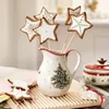 A festive Christmas scene featuring star-shaped cookies in a decorated pitcher, with a small reindeer figurine and a lidded dish in the background. Podgląd zdjęcia produktu