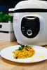 A white Tefal multi-cooker is shown in the background, with a plate of food in the foreground. Podgląd zdjęcia produktu