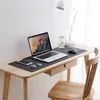 A desk setup with a laptop, mouse, phone, glasses, and a desk mat. Produktbild-Vorschau