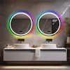 A modern bathroom vanity with two sinks and two illuminated round mirrors above them. Anteprima dell’immagine prodotto