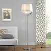 A floor lamp with crystal accents stands next to a sofa and a framed picture on a wall. Anteprima dell’immagine prodotto