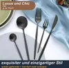 A collection of black cutlery arranged on a light blue satin cloth, with a partial view of a plate in the background. Text overlays highlight luxury and style. Produktbild-Vorschau