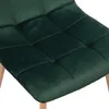 A close-up view of the seat of a dark green velvet chair with wooden legs. Anteprima dell’immagine prodotto
