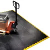 A pallet jack and a bin are on a black interlocking floor mat with yellow edging. Produktbild-Vorschau