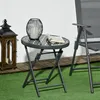 An outdoor scene with a folding table, a lantern, and a chair. Anteprima dell’immagine prodotto