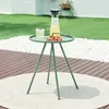 An outdoor side table with a drink and strawberries on it, set on a deck with a lawn and white pebbles in the background. Náhled obrázku produktu