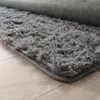 Close-up of a fluffy gray rug on a wooden floor. Voir les images du produit