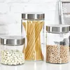 Three glass jars with metal lids containing dry goods: white beans, spaghetti, and chickpeas. Produktbild-Vorschau