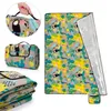 Collage of a folded and unfolded picnic blanket with a tropical bird and cactus pattern. Produktbild-Vorschau