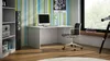 A modern home office setup with a white desk, computer, chair, speaker, and bookshelf. Náhľad obrázku produktu