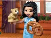 A LEGO Friends character holding a teddy bear and a pretzel in a cozy, festive setting. Náhled obrázku produktu