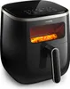 A black Philips air fryer with french fries inside, shown from a side angle. Náhled obrázku produktu