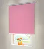 A pink roller blind is shown covering a window, with a view of greenery outside. Produktbild-Vorschau