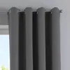 A close-up view of dark gray curtains hanging from a curtain rod. Produktbild-Vorschau