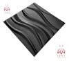 A single black 3D wall panel with a wavy pattern, presented diagonally on a white background. Two logos are visible in the corners. Produktbild-Vorschau