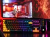 A gaming keyboard and mouse are displayed in front of a computer monitor showing a video game. Anteprima dell’immagine prodotto