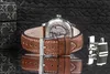A close-up of a watch with a brown leather strap and cufflinks on a reflective black surface. Náhled obrázku produktu