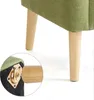 A close-up view of the legs and base of a green armchair, showing the wooden legs and the metal plate where they attach to the chair. Voir les images du produit