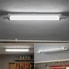 Collage of images showing an LED light fixture installed in different settings, including a workshop and a garage. Produktbild-Vorschau