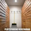 A broom is hung on a wall in a hallway with wooden paneling on either side. Produktbild-Vorschau