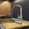 A modern kitchen sink area with a beige faucet, oranges in a sink rack, and a wooden cutting board. Podgląd zdjęcia produktu