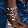 A close-up shot of a person's arm wearing two Pandora charm bracelets, with a denim jacket in the background. Produktbild-Vorschau