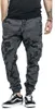 A person is wearing camouflage cargo pants and sneakers. Produktbild-Vorschau