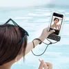 A person in a swimming pool is taking a selfie with a smartphone in a waterproof case. Anteprima dell’immagine prodotto
