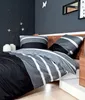 A bedroom scene with a bed featuring a striped duvet and pillows. Voir les images du produit