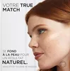 A woman's face with foundation swatches applied to her cheek. Voir les images du produit
