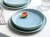 A table setting with blue plates and a fig on one of them. Náhľad obrázku produktu