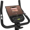 Close-up view of the console and handlebars of an exercise bike, with a tablet mounted on it displaying a music app. Produktbild-Vorschau