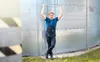 A man in overalls stands next to a large industrial silo. Náhled obrázku produktu
