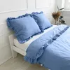 A neatly made bed with blue bedding and pillows. Produktbild-Vorschau