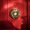 A Christmas advent calendar shaped like a wreath hangs on a red wall above a red sofa. Produktbild-Vorschau