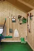 Garden tools organized on a wall rack inside a wooden shed. Anteprima dell’immagine prodotto