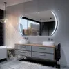 A modern bathroom vanity with a large oval LED mirror above it, reflecting a city view. Produktbild-Vorschau